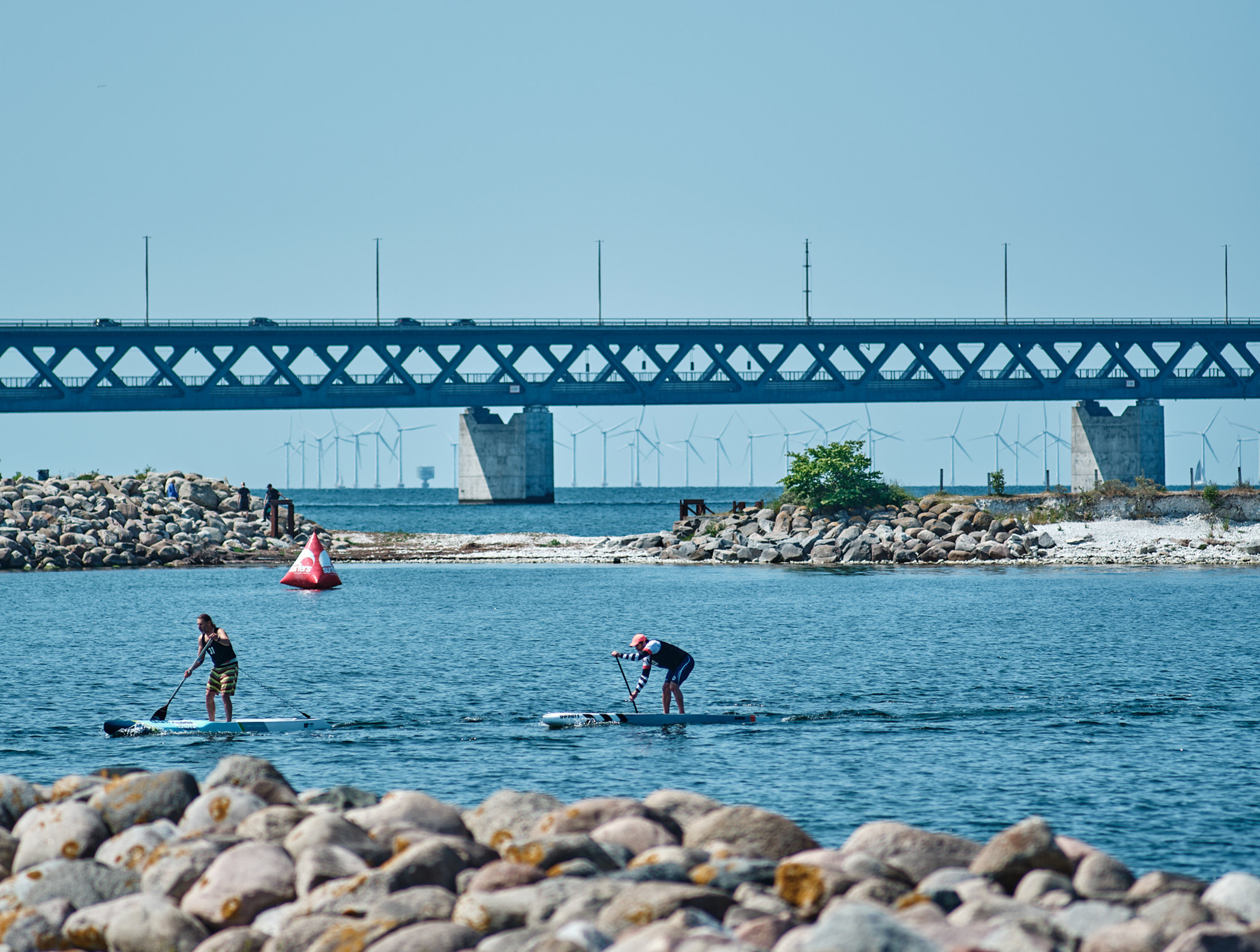 Två paddlare på SUP med bro i bakgrunden på tävlingen Malmö Ocean Race. Fotograf Morten Bruhn